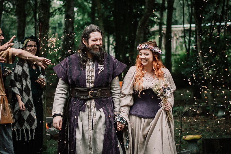 The couple being 'seasoned' with confetti petals and rosemary